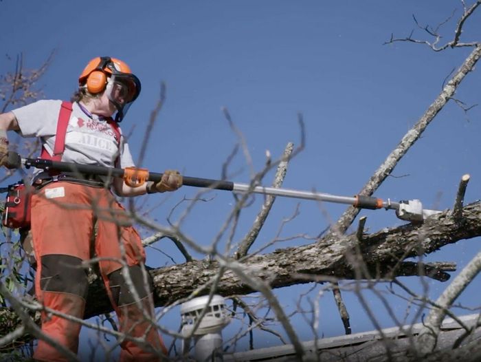 a Team Rubicon volunteer clears a dangerous tree branch